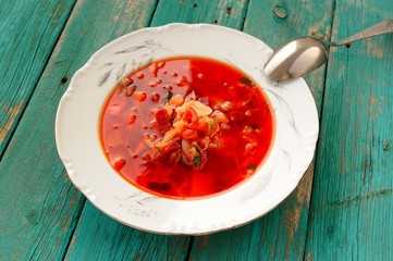 Russian vegetarian borsch with cabbage in white plate on turquoi