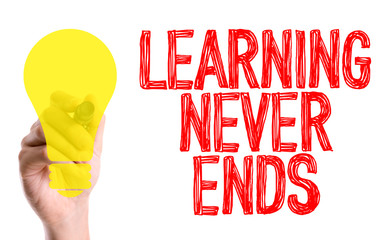 Hand with marker writing the word Learning Never Ends