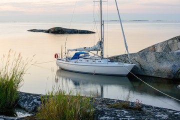 Sailboat moored long side a small rocky island © mbroms