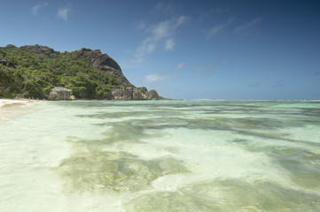 Fototapeta na wymiar Paradise beach of Seychelles in la Digue island, Anse Source d'Argent. Boulders black granite rocks, turquoise water, white sand and blue sky.