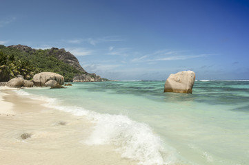 Paradise beach of Seychelles in la Digue island, Anse Source d'Argent. Boulders black granite rocks, turquoise water, white sand and blue sky.