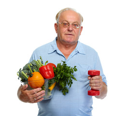 Senior man with vegetables and dumbbell.