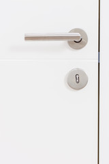 Gray metal handle on a white door
