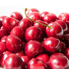 Bowl of red fresh cerries on a white background