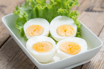 Sliced boiled eggs on white plate.