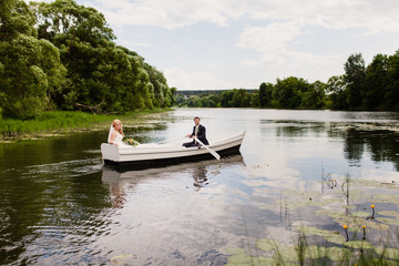 жених и невеста в белой лодке на озере