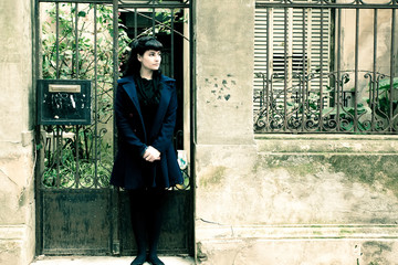 Retro girl in front of a old house.