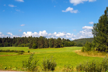 Obraz premium Landscape of the field with great sky and clouds panoramic. Panorama meadow farm fields. Nature in summer. Wheat and mown grass. Big clouds. Rustic panoramic picture. Autumn meadow.