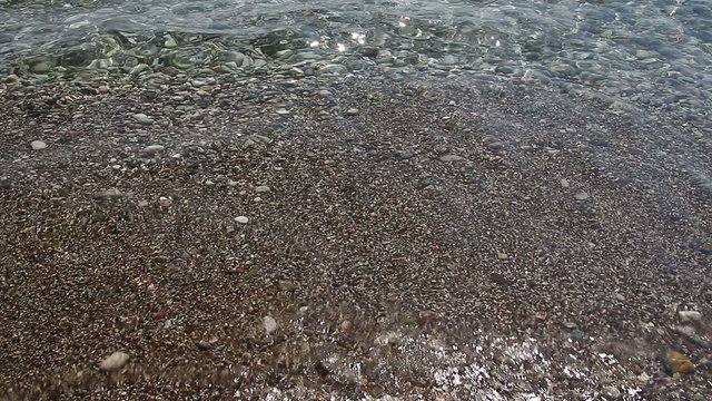 Background of Transparent waves of the sea run over on the beautiful pebble beach