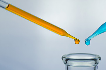 science laboratory pipette with drop on test tube background , l