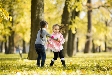 Two little girls at the autumn park