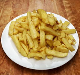 Potator Chips on white dish on wooden table top
