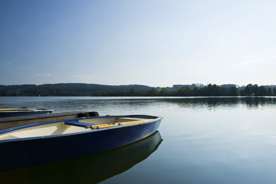 Ruderboot am Steg eines Sees
