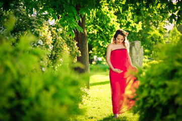 Pretty pregnant woman in red outdoors