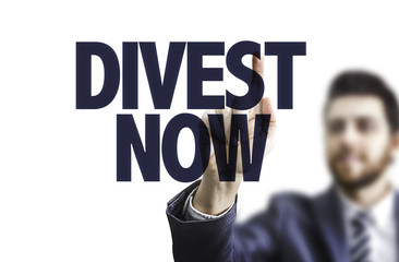 Business man pointing the text: Divest Now