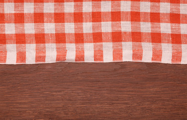 Fototapeta na wymiar Tablecloth red and white checkered wavy on wooden table