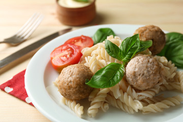 Pasta with meatballs on plate, on wooden  table background