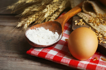 Flour and wheat on wooden table, closeup