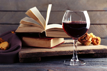 Beautiful composition with glass of wine with old books on table close up