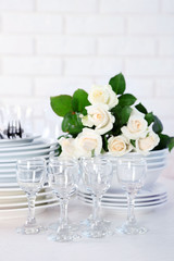 Clean plates, glasses and cutlery on white table
