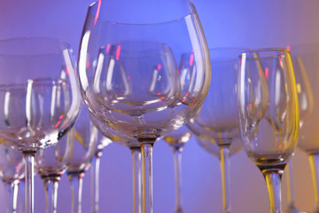 Empty wine glasses on color background