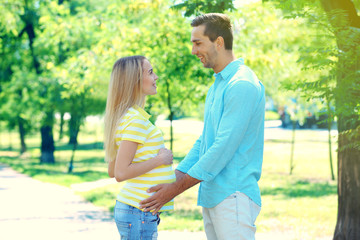 Fototapeta premium Young pregnant woman with husband in park