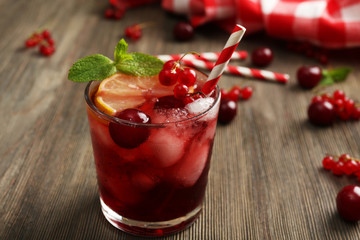 Glass of berry juice on wooden table, closeup