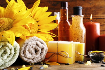 Obraz na płótnie Canvas Spa treatments and sunflower on wooden background