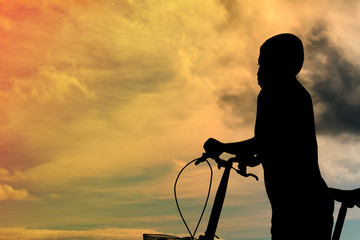 Children and bike silhouette on the sand beach.