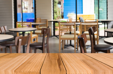 Selected focus empty brown wooden table and Coffee shop blur bac