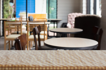 checkered table cloth on empty table and restaurant or cafe for