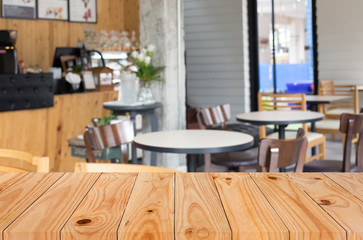 Selected focus empty brown wooden table and Coffee shop blur bac
