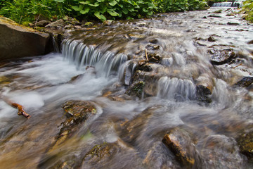 Naklejka na ściany i meble stones and mountain river with small waterfall, background