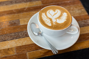 Hot art Latte Coffee in a cup on wooden table