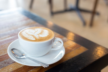 Hot art Latte Coffee in a cup on wooden table