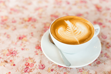 Cup of art latte or cappuccino coffee with retro filter effect a
