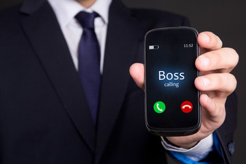 business man's hand holding smart phone with incoming boss call