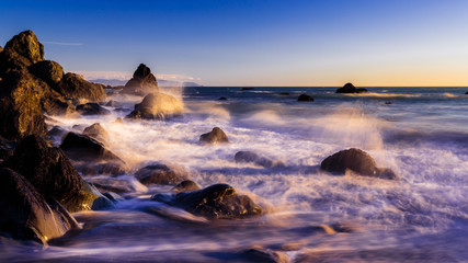 Fototapeta na wymiar crashing waves at dreamy california beach at sunset