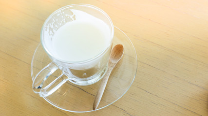 hot drink milk with spoon on wood table