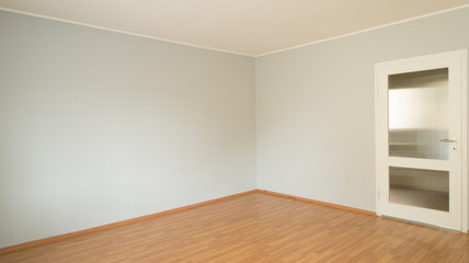 Empty room with gray wall and parquet floor
