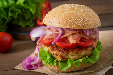 Big sandwich - hamburger burger with beef, red onion, tomato and fried bacon.
