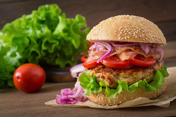 Big sandwich - hamburger burger with beef, red onion, tomato and fried bacon.