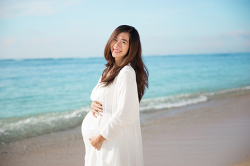 Fototapeta na wymiar Happy asian pregnant woman smile while touching her tummy on the