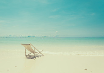 beach chair on beach with blue sky - soft focus with film filter