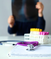 Medical doctor  sitting at table and looking patients roentgen