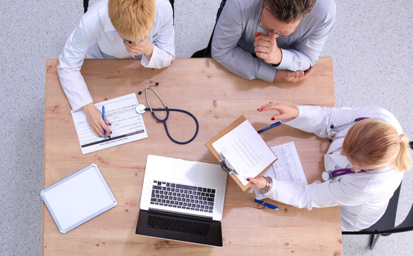 Male and female doctors working on reports in medical office