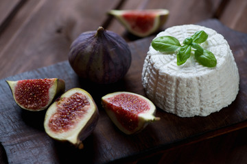 Ricotta with green basil and ripe sliced fig fruits, close-up