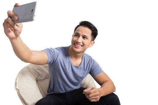 young attractive man taking pictures of him self (selfie) with s