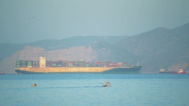 Cargo ship enters the port in tow