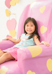 Obraz na płótnie Canvas Cute girl siting relax on pink sofa.